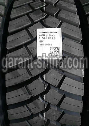 Bridgestone M-Drive 001 (привод-карьер) 315/80 R22.5 156/150K 20PR - Фото протектора с этикеткой вблизи